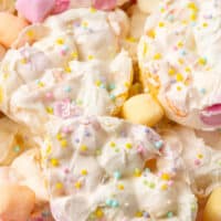 picture of easter marshmallow bark egg pieces piled on a plate with the title of the post on top in pink and black lettering