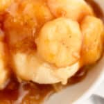 square close up image of bananas foster topping over vanilla ice cream