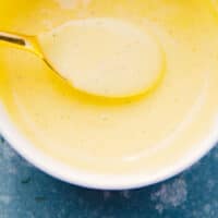blender hollandaise sauce in a bowl with a spoon with recipe name at the bottom