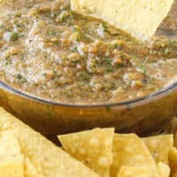 close up of easy blender salsa in a bowl with a chip with recipe name at the bottom