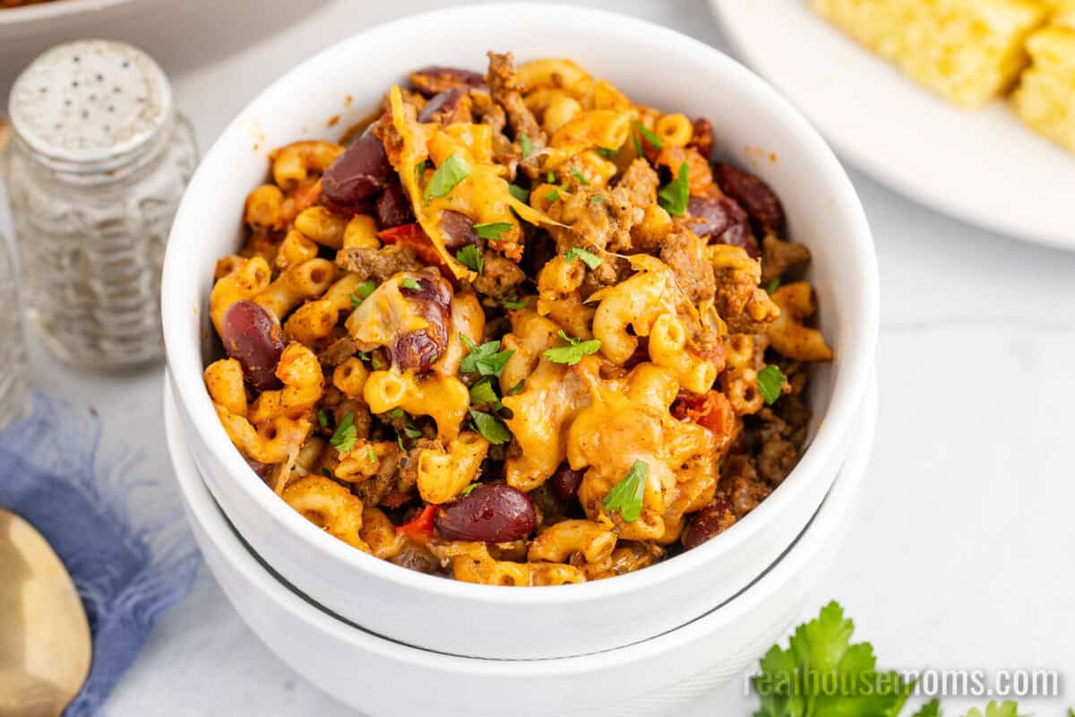 bowlful of chili mac topped with chopped parsley