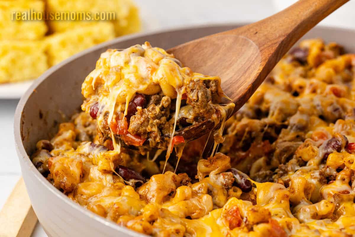 close up of a spoonful of chili mac over the skillet