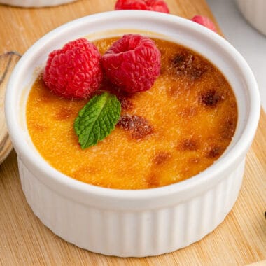 square image of easy creme brulee topped with fresh raspberries and mint