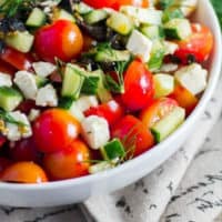 White bowl with tomatoes cucumbers and feta cheese tossed together to make Easy Dinner Ideas Tomato and Cucumber Salad