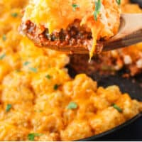 spoonful of sloppy joe casserole over the skillet with recipe name at the bottom