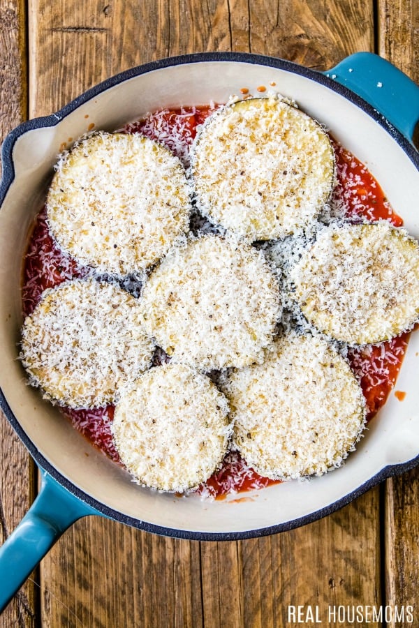 tomato sauce, sliced eggplant, and breadcrumbs in a pan for eggplatn parmesan