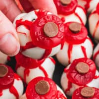 image of hand holding a eyeball oreo ball over the plate with the title of the post on top of the image in red and black lettering