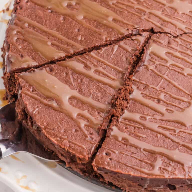 square image of a slice of flourless chocolate cake being taken from the cake