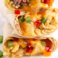 three freezer breakfast burritos stacked up with recipe name at bottom