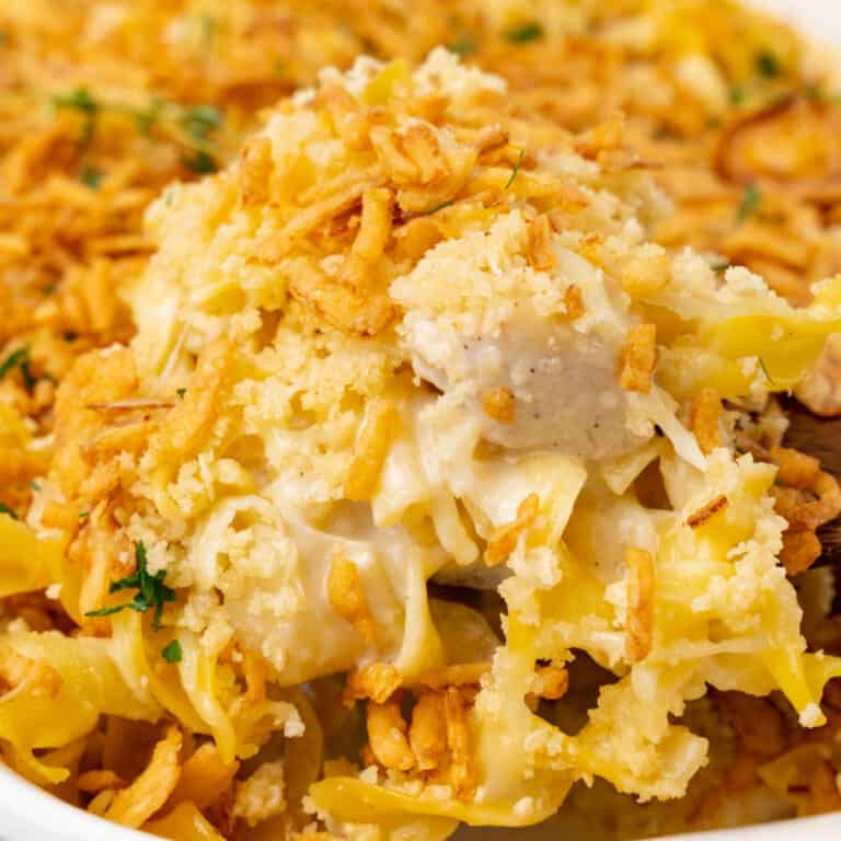 square image of a spoonful of french onion chicken casserole over the baking dish
