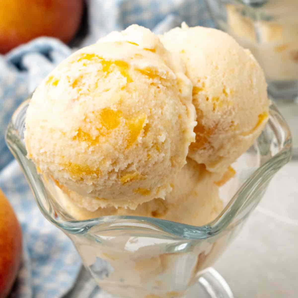 square image of peach ice cream in a glass dessert bowl