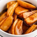 square close up image of fried apples in a white bowl