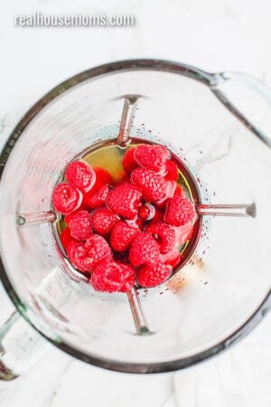 looking down into a blender with tequila, sweet & sour, grand marnier, and raspberries
