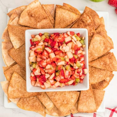 square image of fruit salsa in a bowl surrounded by cinnamon sugar chips