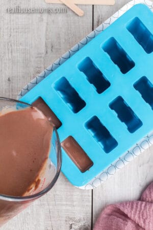 fudgesicle mixture being poured into popsicle molds