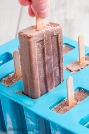 homemade fudgesicle being pulled from a popsicle mold