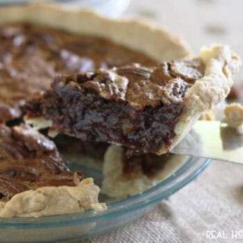 slice of chocolate pecan pie on a cake server being taken from the pie plate