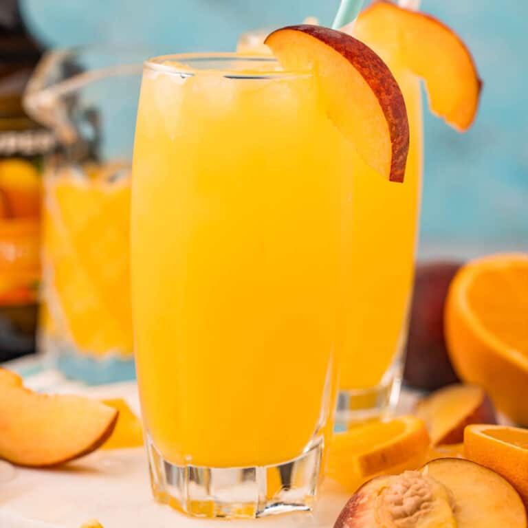 square image of fuzzy navel cocktail with a peach slice for garnish