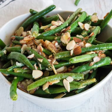 Need a healthy side dish with tons of flavor? This Garlic, Lime & Almond Green Bean recipe is it! Bright lime and garlic are the perfect way to dress up these beans!