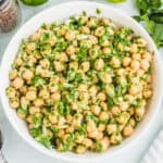 square image of garbanzo bean salad with cilantro lime dressing in a white serving bowl