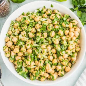 square image of garbanzo bean salad with cilantro lime dressing in a white serving bowl