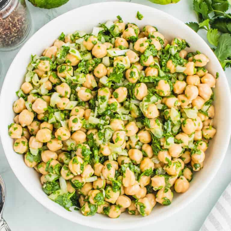 square image of garbanzo bean salad with cilantro lime dressing in a white serving bowl