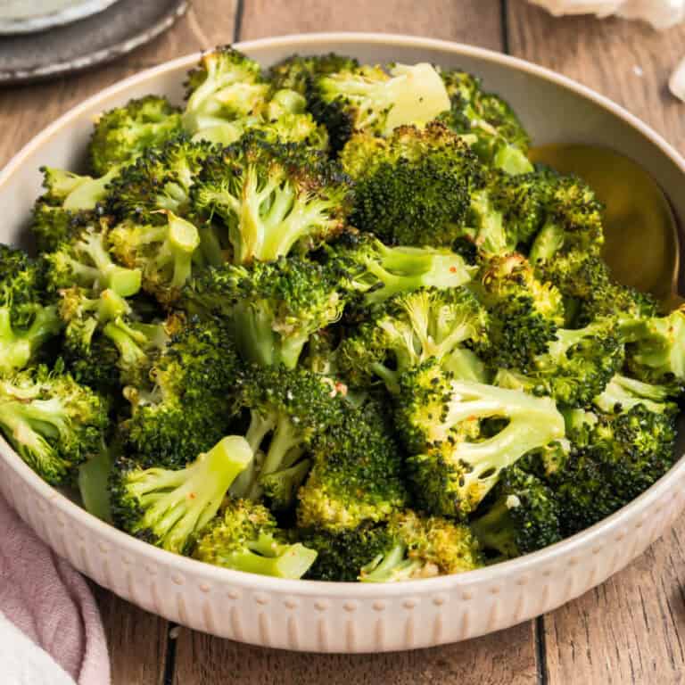square image of garlic roasted broccoli in a serving bowl
