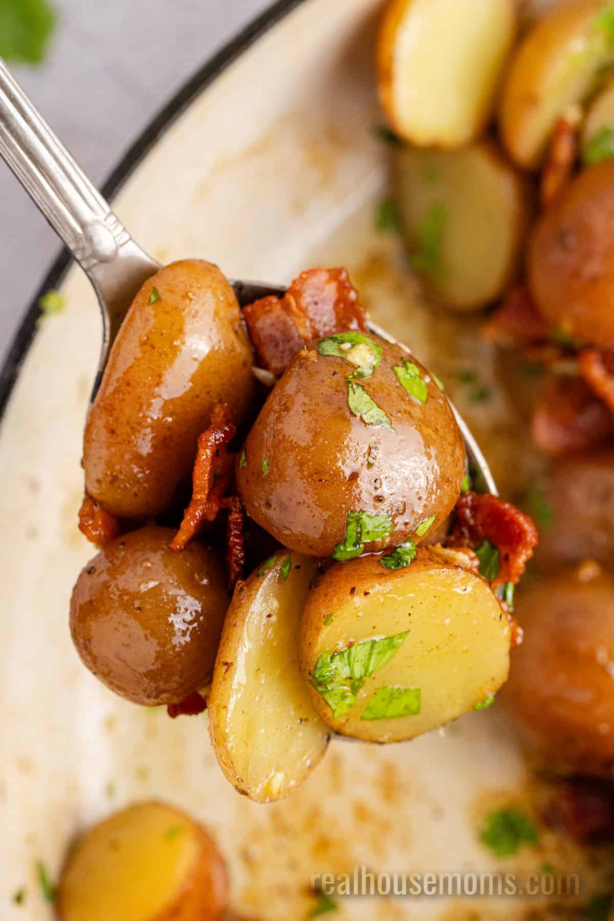 close up of a spoonful of german potato salad over the skillet