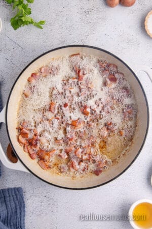 cooked chopped bacon and bacon grease in a large skillet