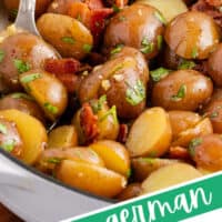 close up image of german potato salad with a serving spoon in a white ceramic skillet with the title of the post on the bottom