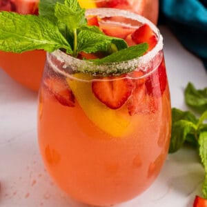 square image of giggle juice in a sugar rimmed wine glass with mint garnish