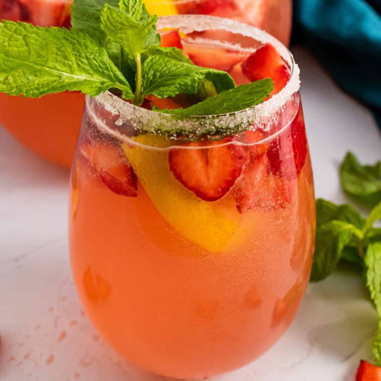 square image of giggle juice in a sugar rimmed wine glass with mint garnish
