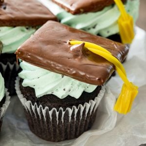Chocolate cupcakes, whipped mint chocolate chip cream cheese frosting, and a graduation cap and tassel! These Graduation Cupcakes or should we say “cap”-cakes are perfect for impending Graduation parties!