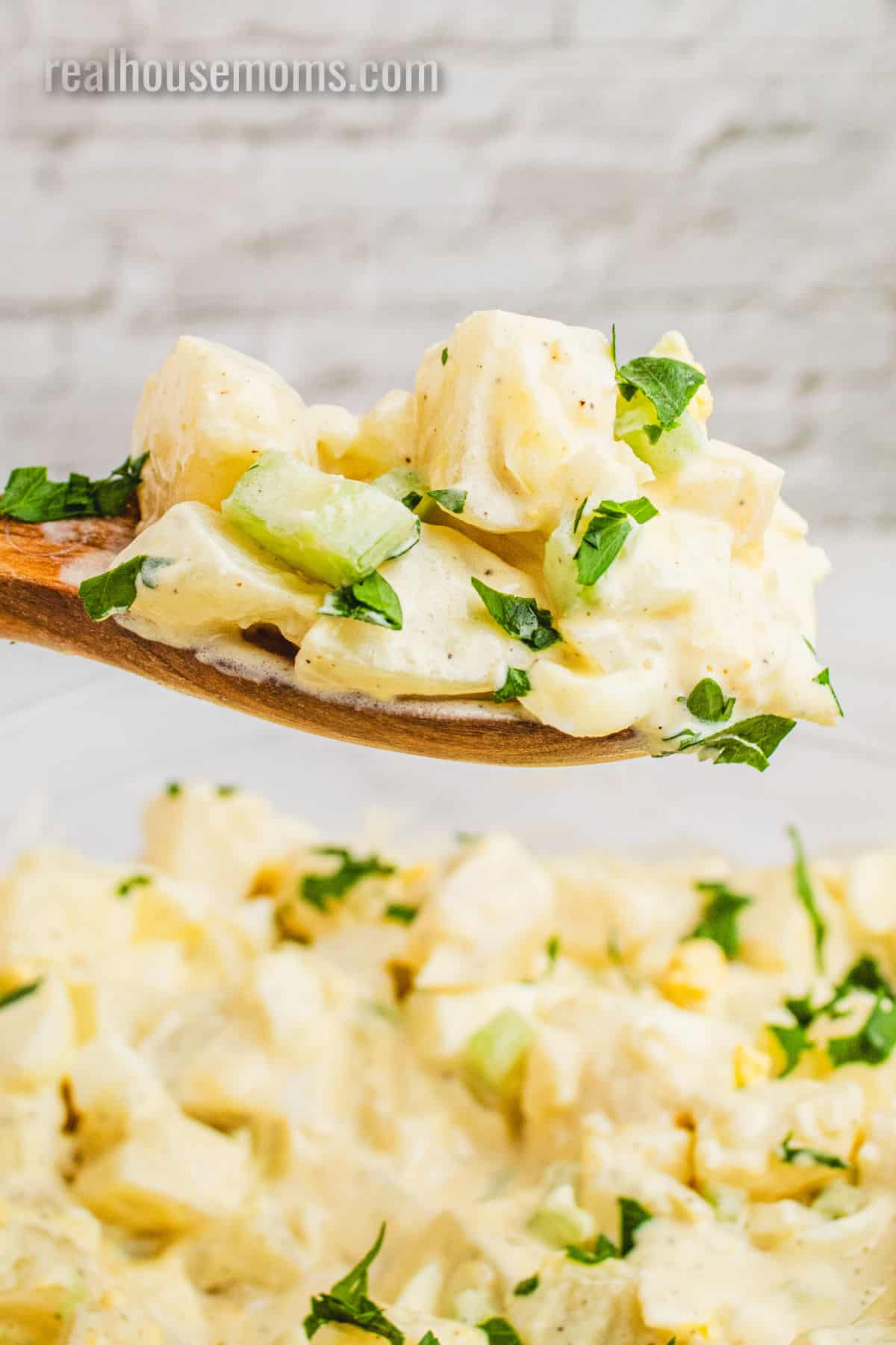 spoonful of grandma's potato salad over the serving bowl