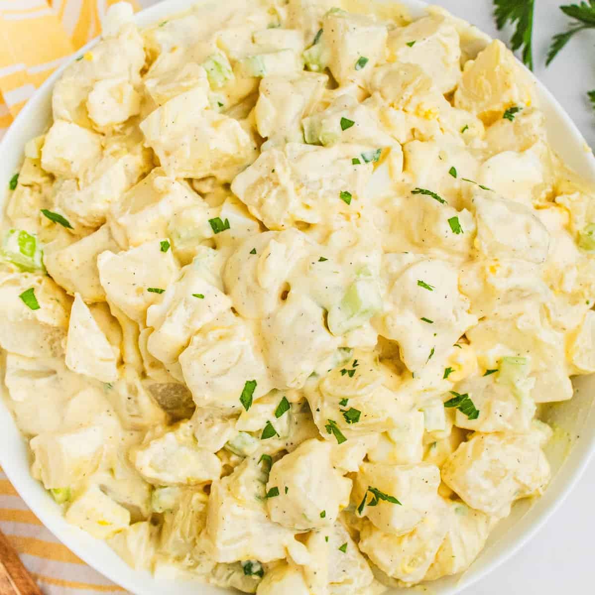 square image of grandma's best potato salad recipe in a white serving bowl