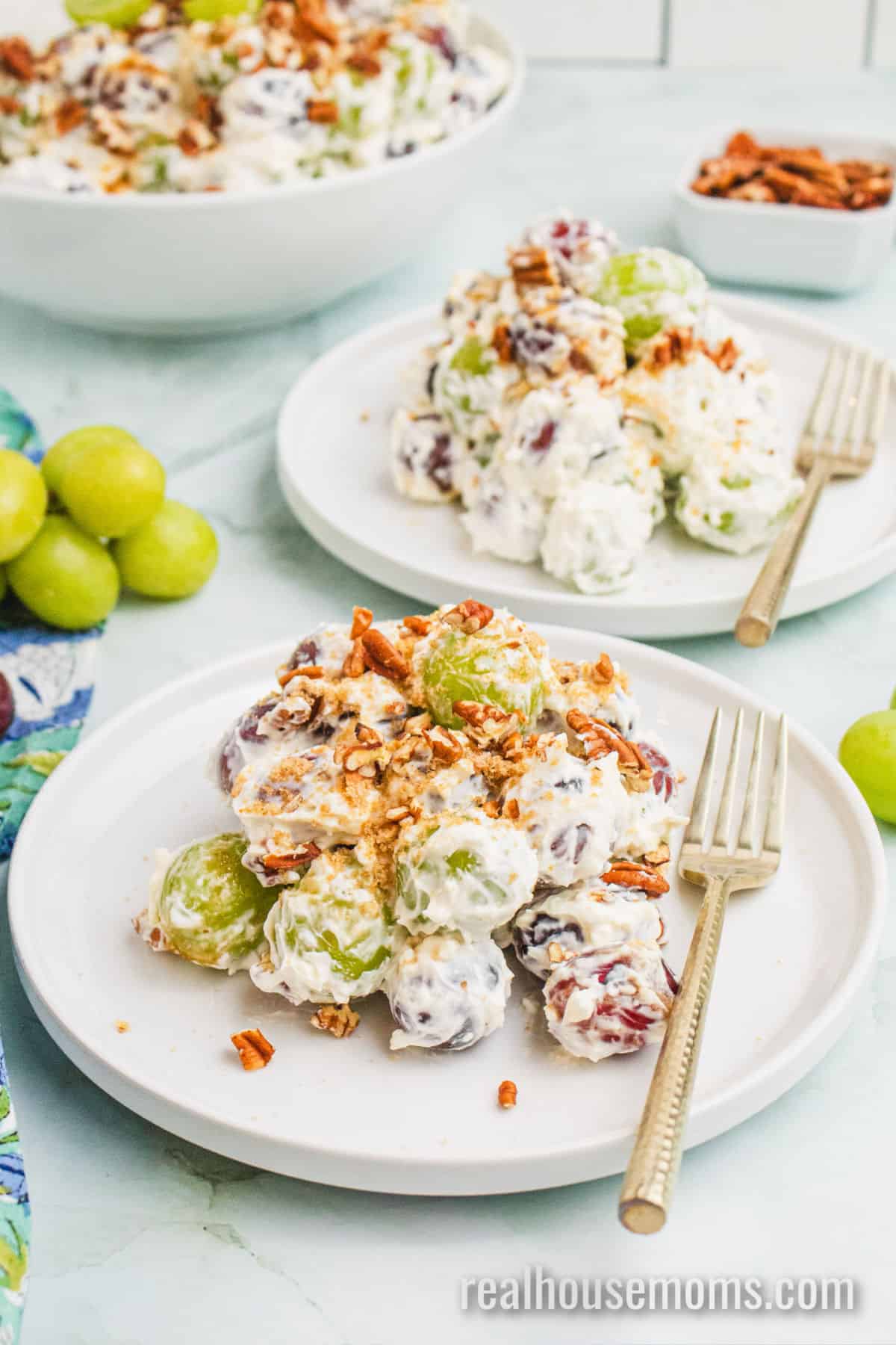 servings of grape salad on a small plates with fork net to the serving bowl