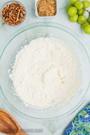 cream cheese grape salad dressing in a glass mixing bowl