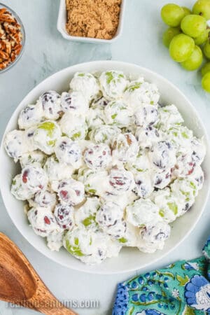 grapes coated in sweetened cream cheese mixture in a serving bowl