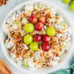 square image of grape salad toped with extra red and green grapes in a serving bowl