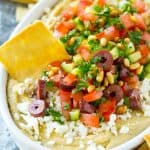 This easy Greek Layered Dip is the perfect 10-minute party appetizer that's a total crowd pleaser. Serve this dip with pita chips or fresh veggie and watch it disappear!