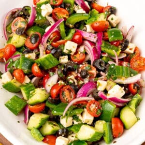 square close up image of greek salad in a serving bowl