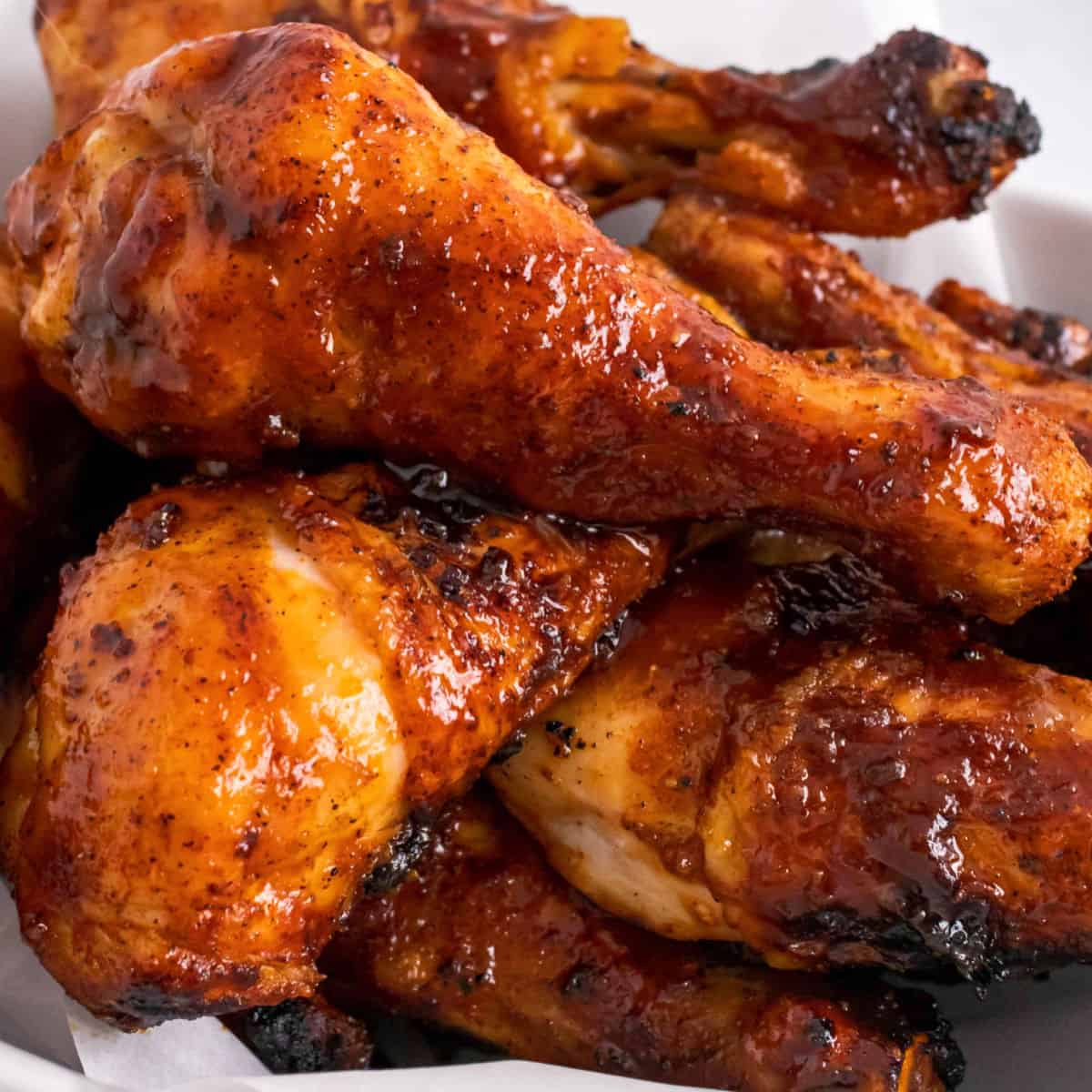 square image of bbq chicken legs piled up