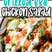 grilled chicken on top of a salad with dressing