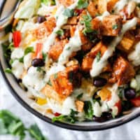 bowl of salad with chicken and dressing