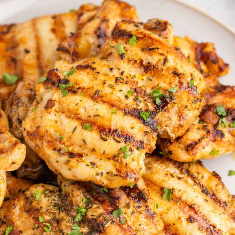 square image of grilled chicken thighs on a plate