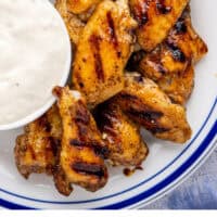 grilled honey hot wings on a plate with a bowl of blue cheese with recipe name at the bottom