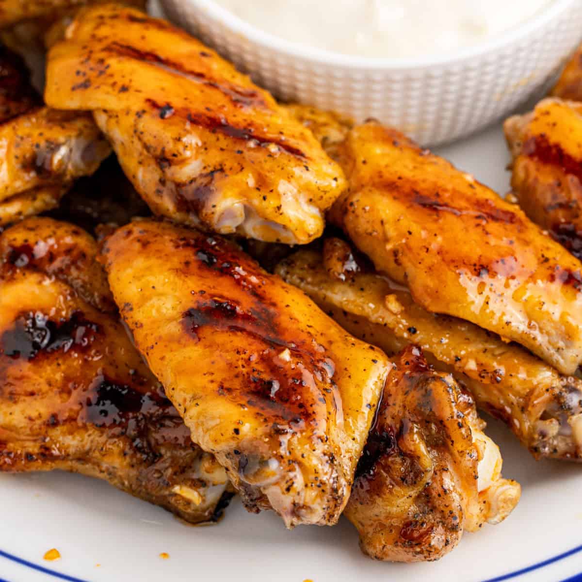 square image of grilled honey hot wings on a plate