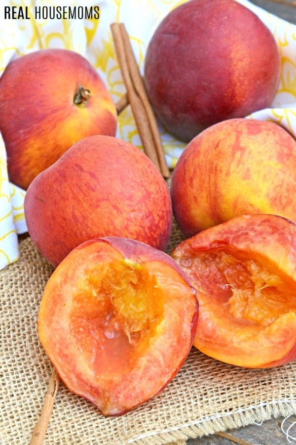 peaches on a counter with one halved and pitted