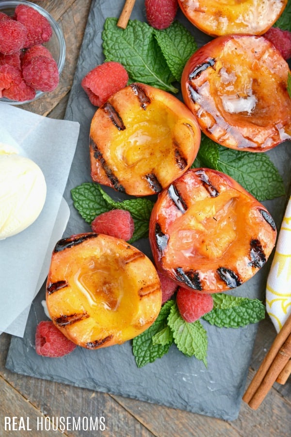 overhead picture of grilled peaches with mint and raspberries