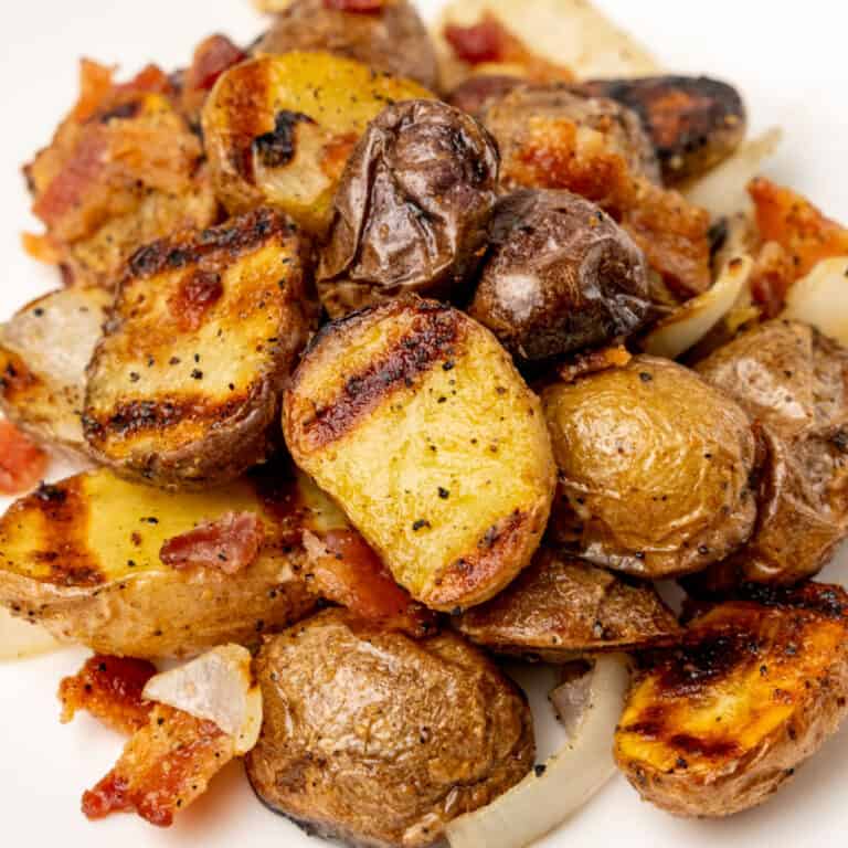 square close up image of grilled potato salad on a plate